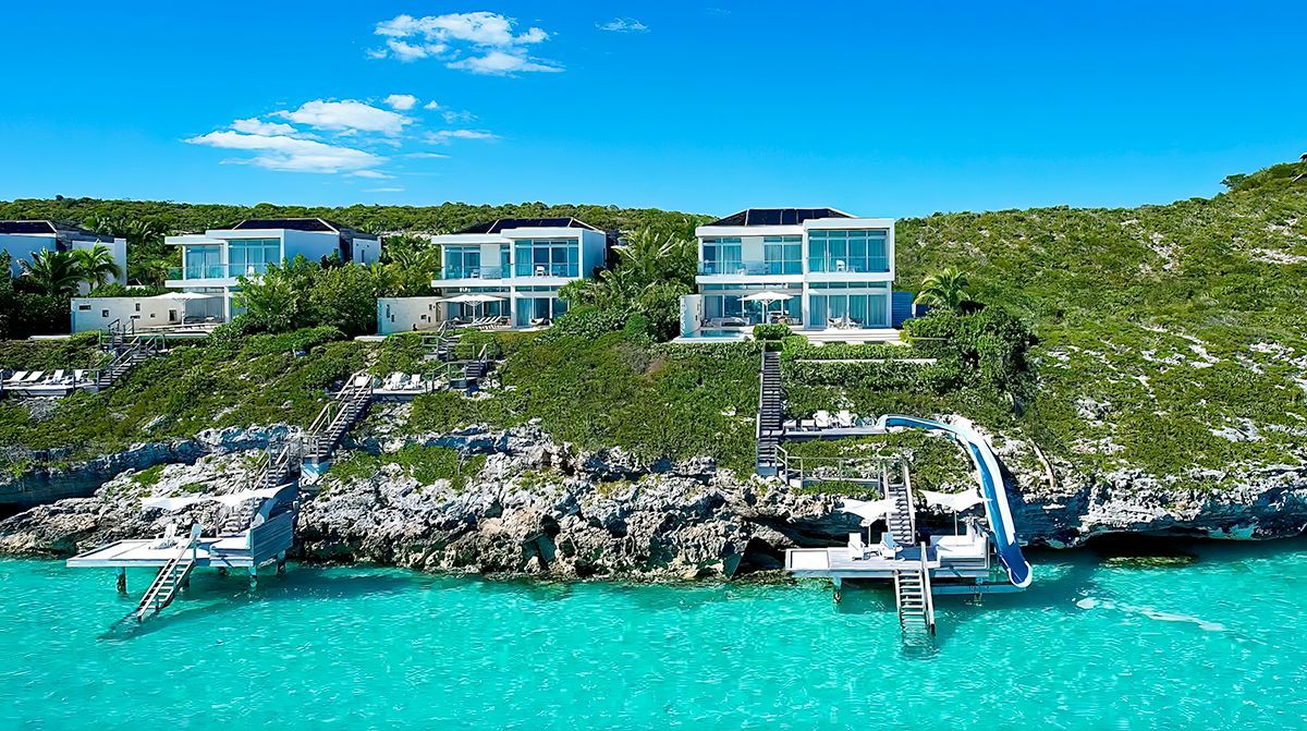 a couple of villas on a cliff overlooking a body of water