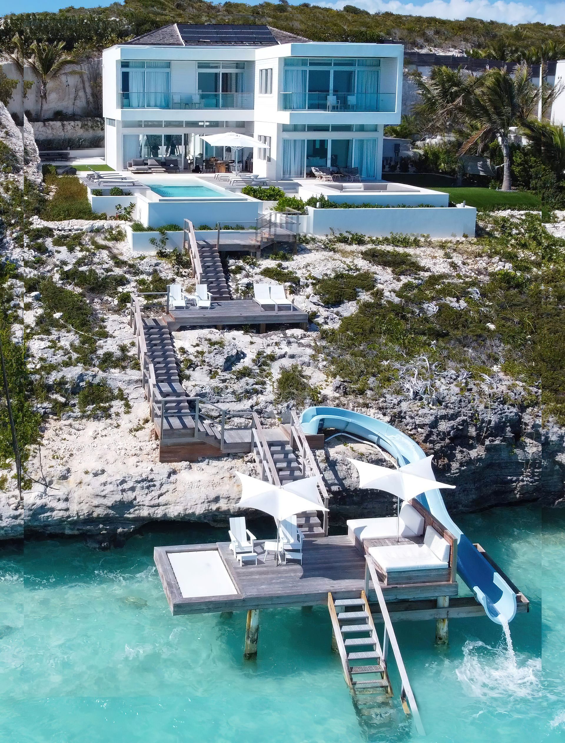 An aerial view of a house with a water slide in front of it
