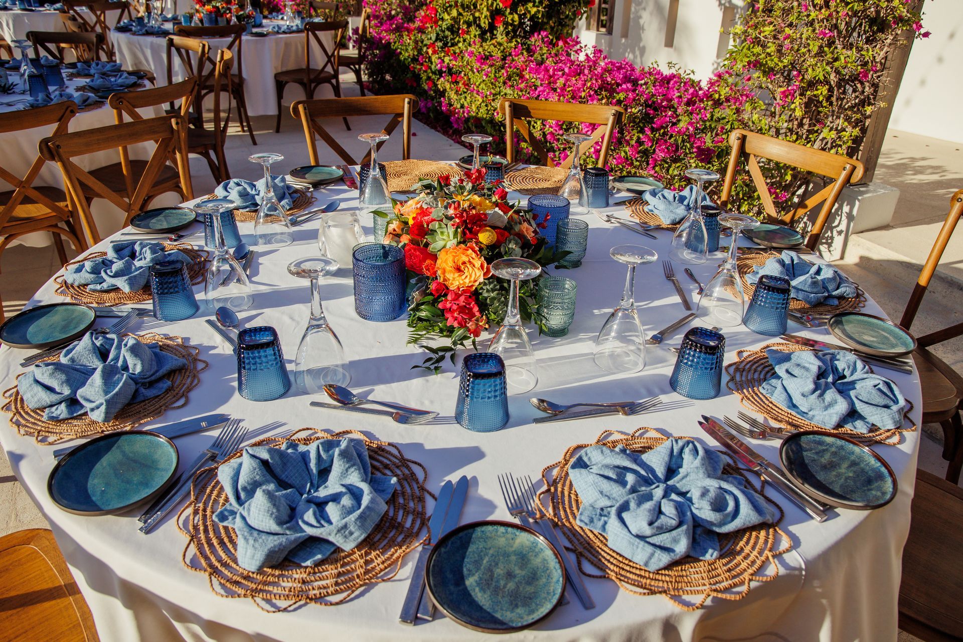 A table set for a wedding reception with blue plates and glasses