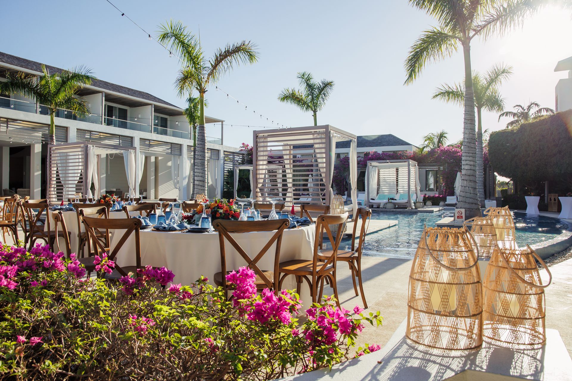 Tables and chairs are set up in front of a swimming pool