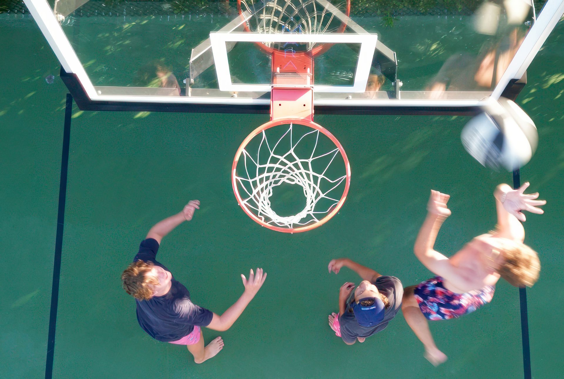 A group of children are playing basketball on a court