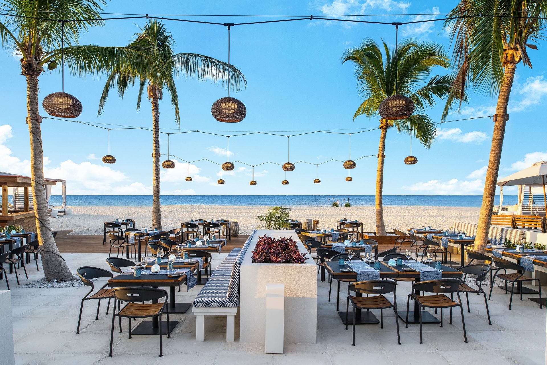 A restaurant on the beach with tables and chairs