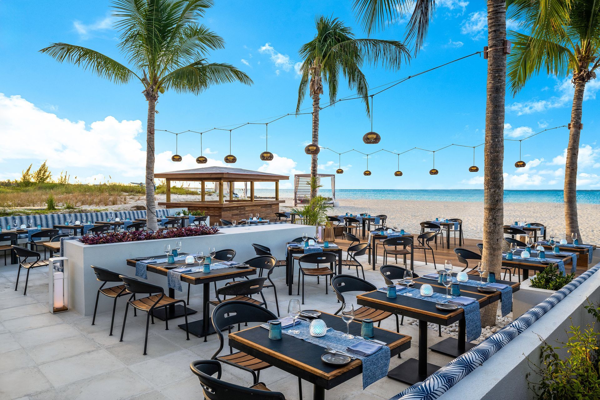 A restaurant on the beach with tables and chairs