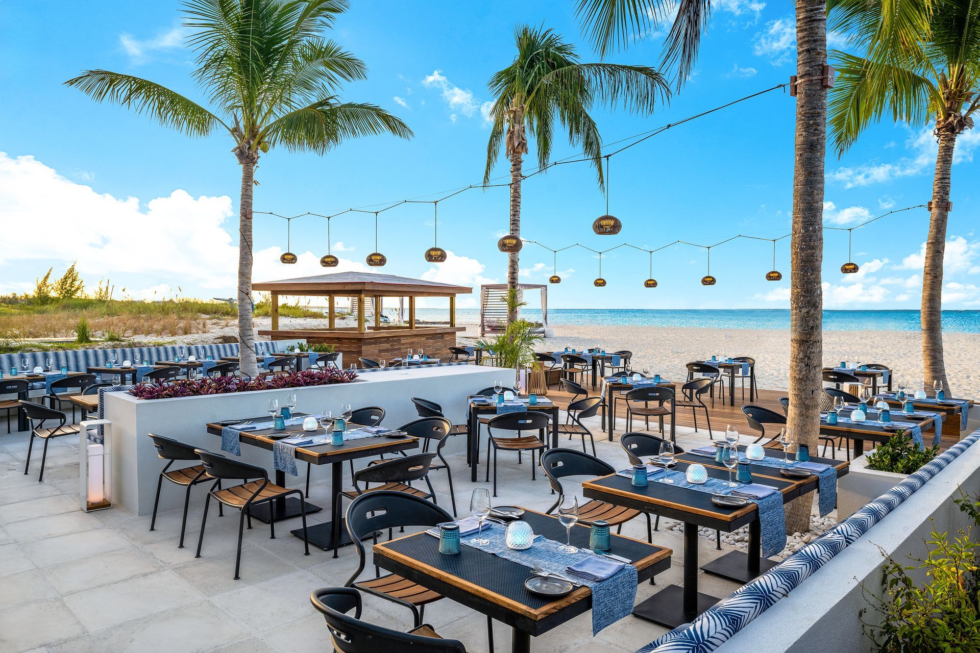 A restaurant on the beach with tables and chairs