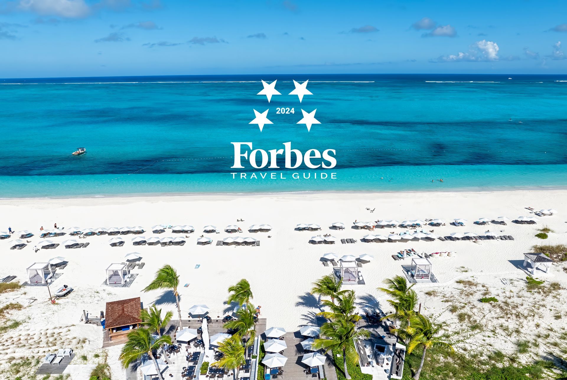 An aerial view of a beach with the forbes logo in the background