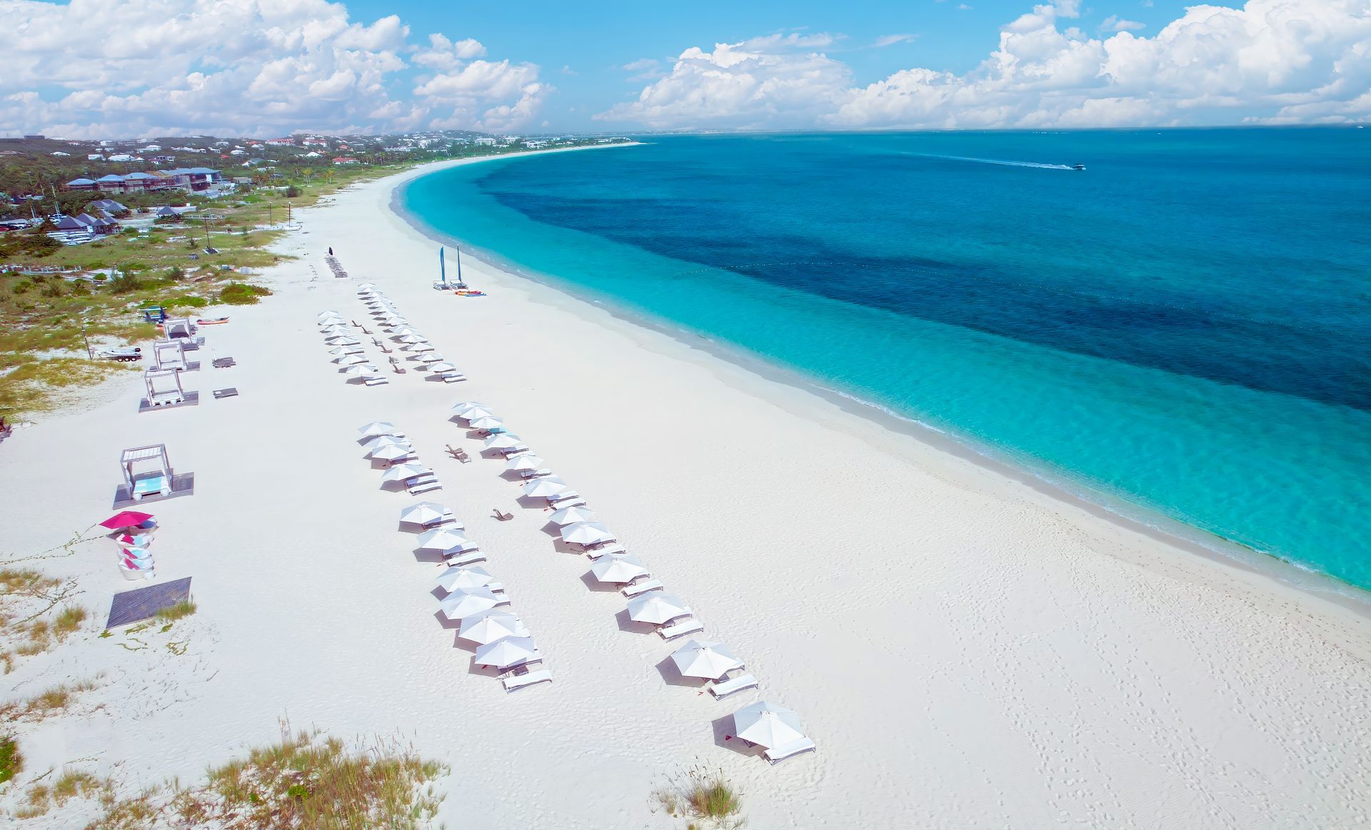 An aerial view of a beach with umbrellas and chairs