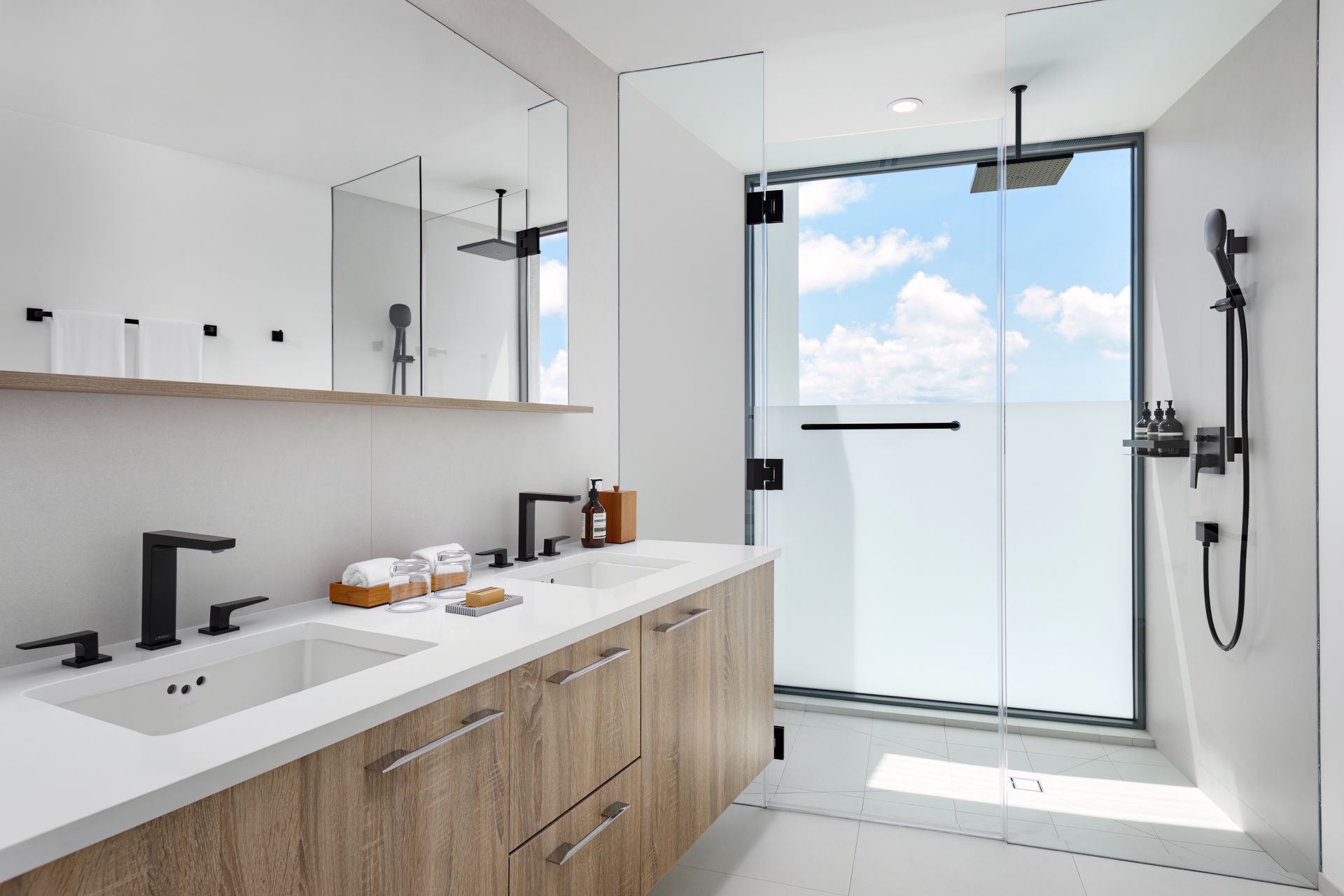 A bathroom with two sinks and a walk in shower