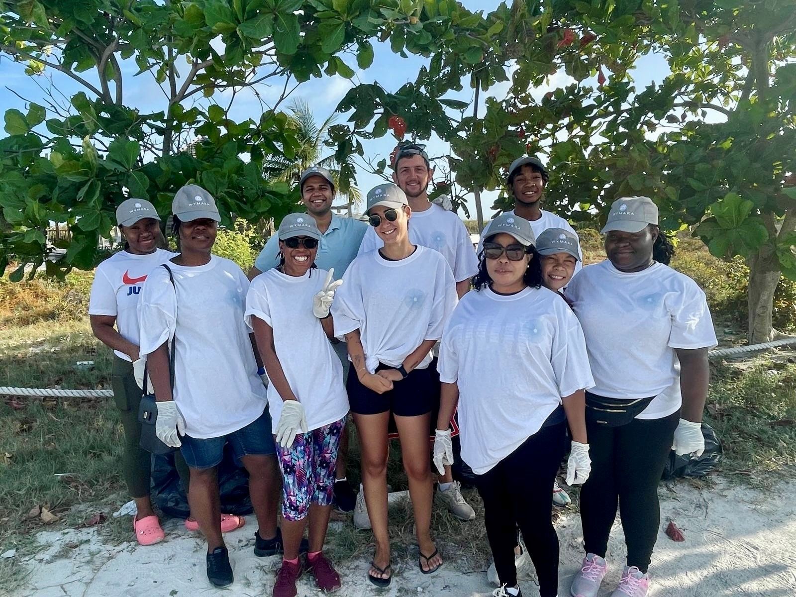 A group of people wearing white shirts and hats are posing for a picture