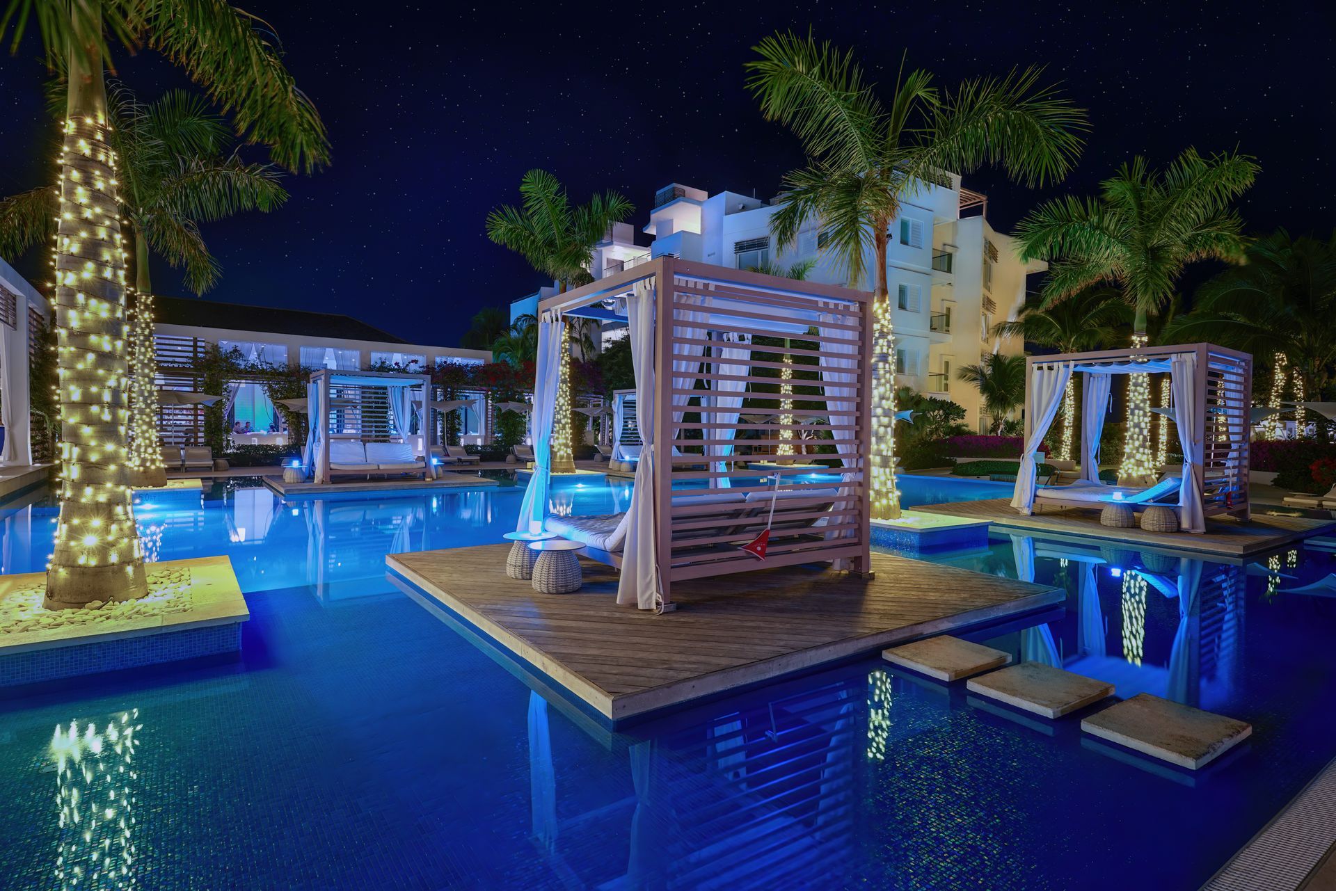 A large swimming pool is lit up at night