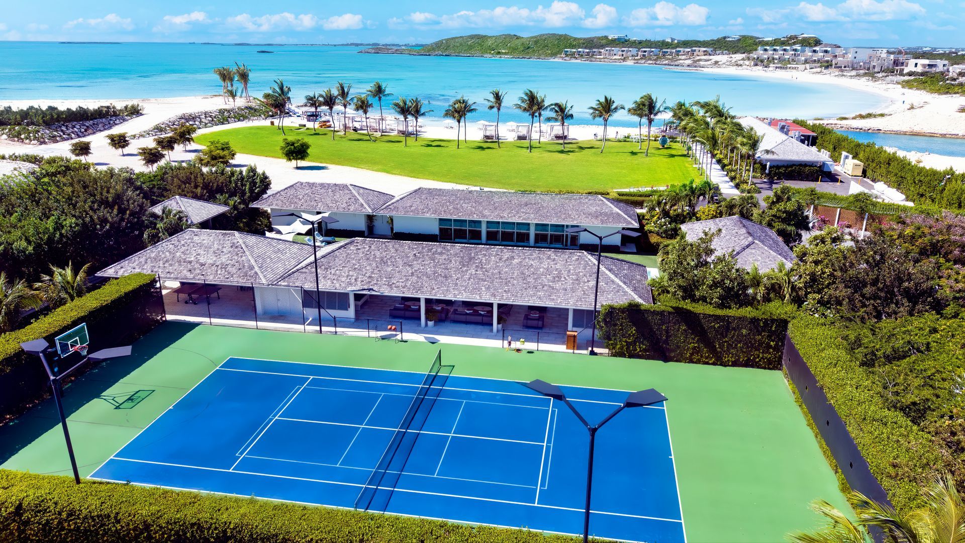 An aerial view of a tennis court with the ocean in the background