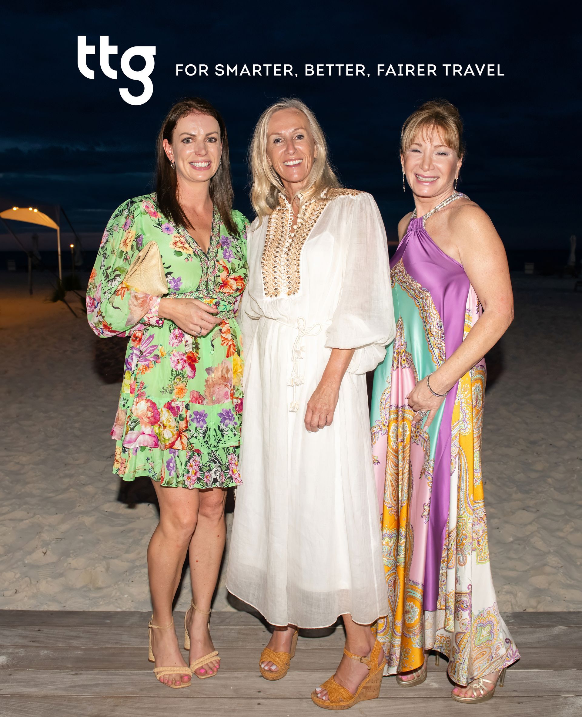 Three women are posing for a picture with the ttg logo in the background