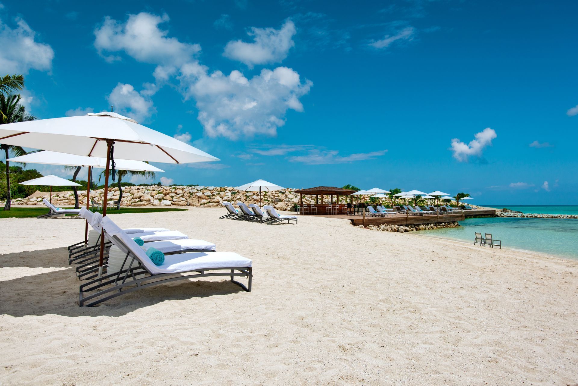 A beach with chairs and umbrellas on a sunny day