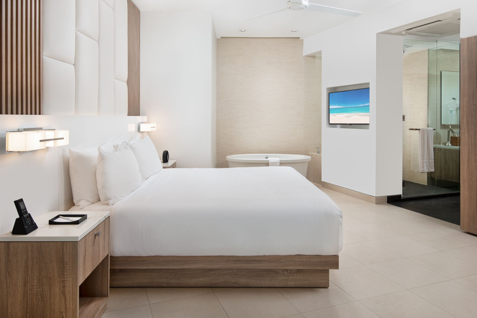 A hotel room with a king size bed and a television