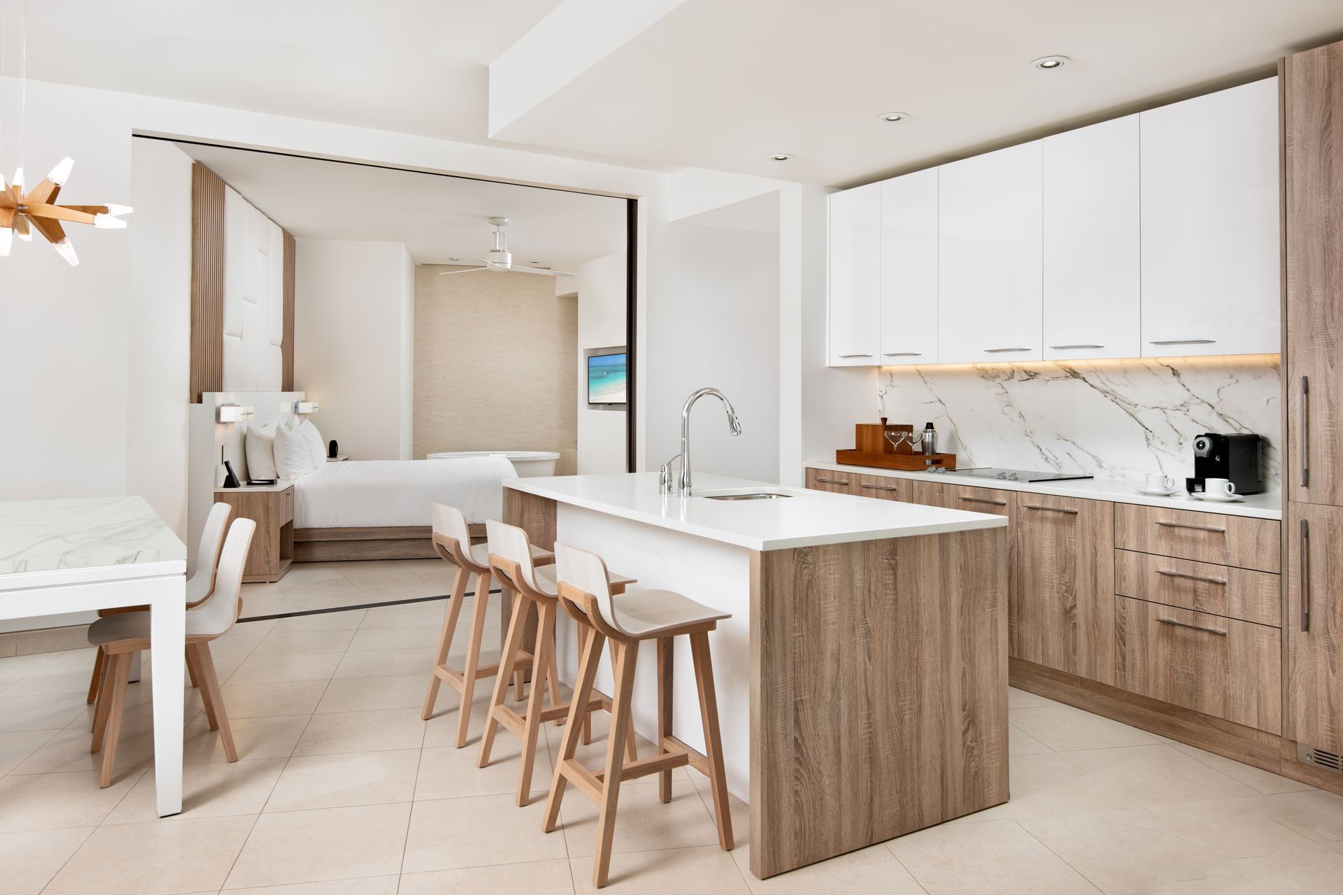 A kitchen with white cabinets and wooden stools