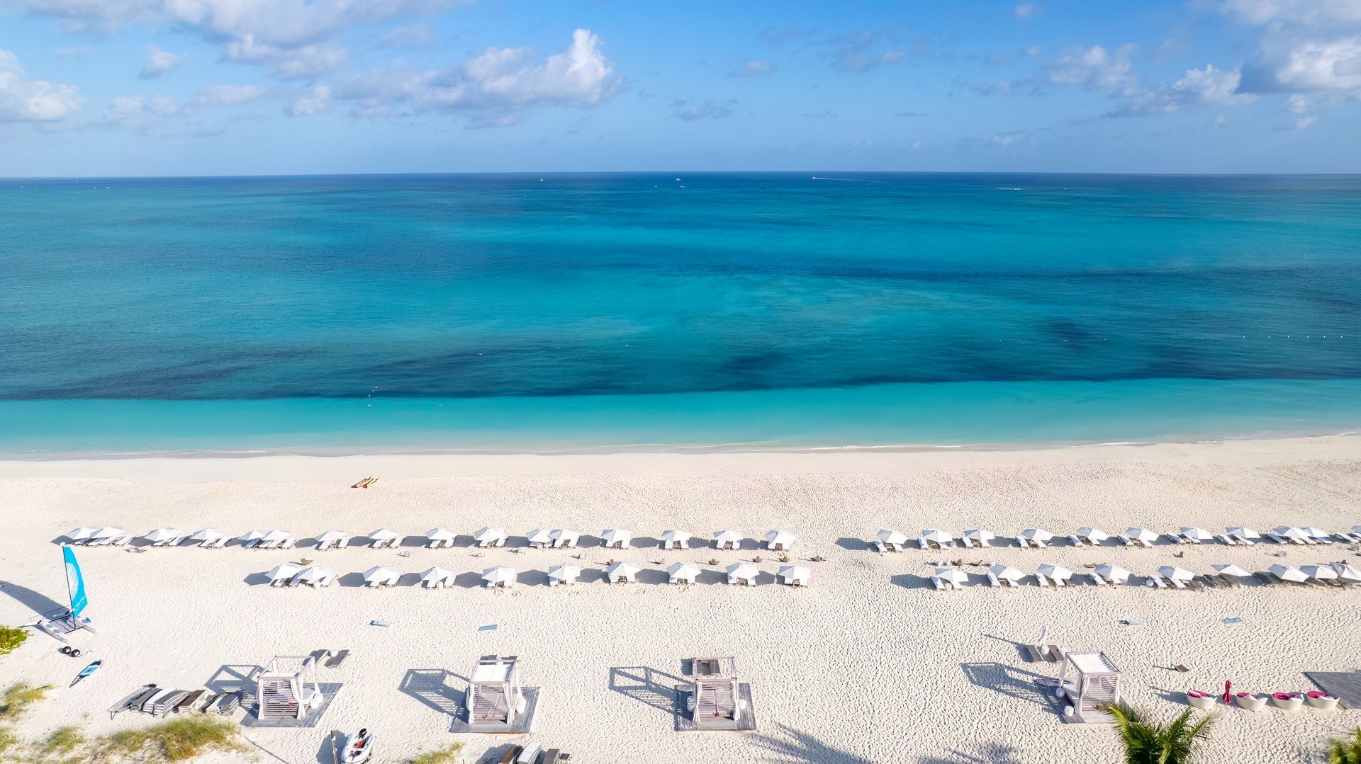 An aerial view of a beach with white sand and turquoise water