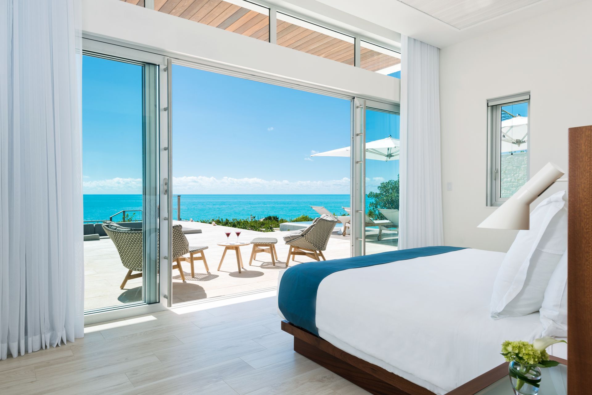 A bedroom with a bed and a view of the ocean