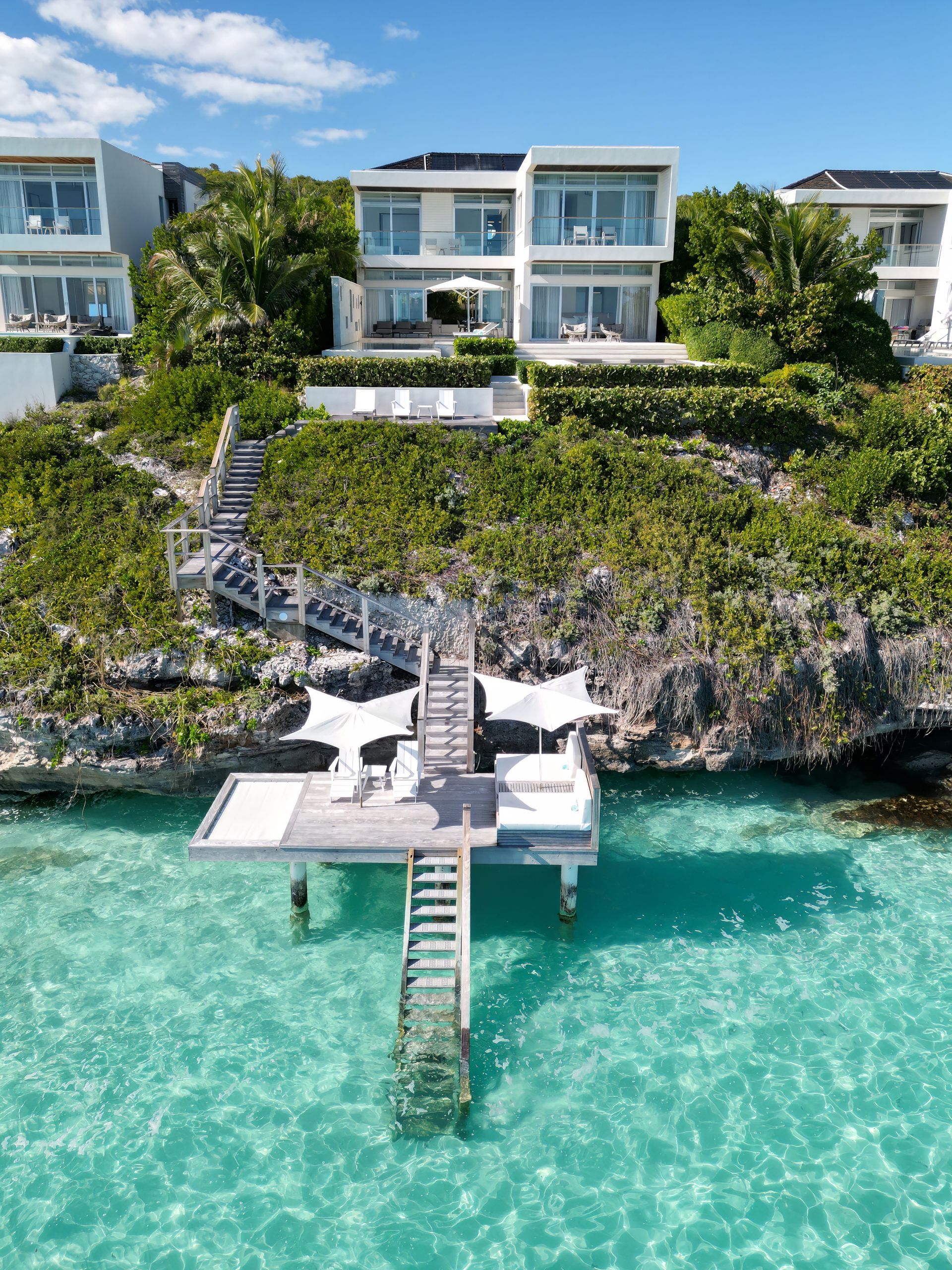 An aerial view of a dock leading to a house