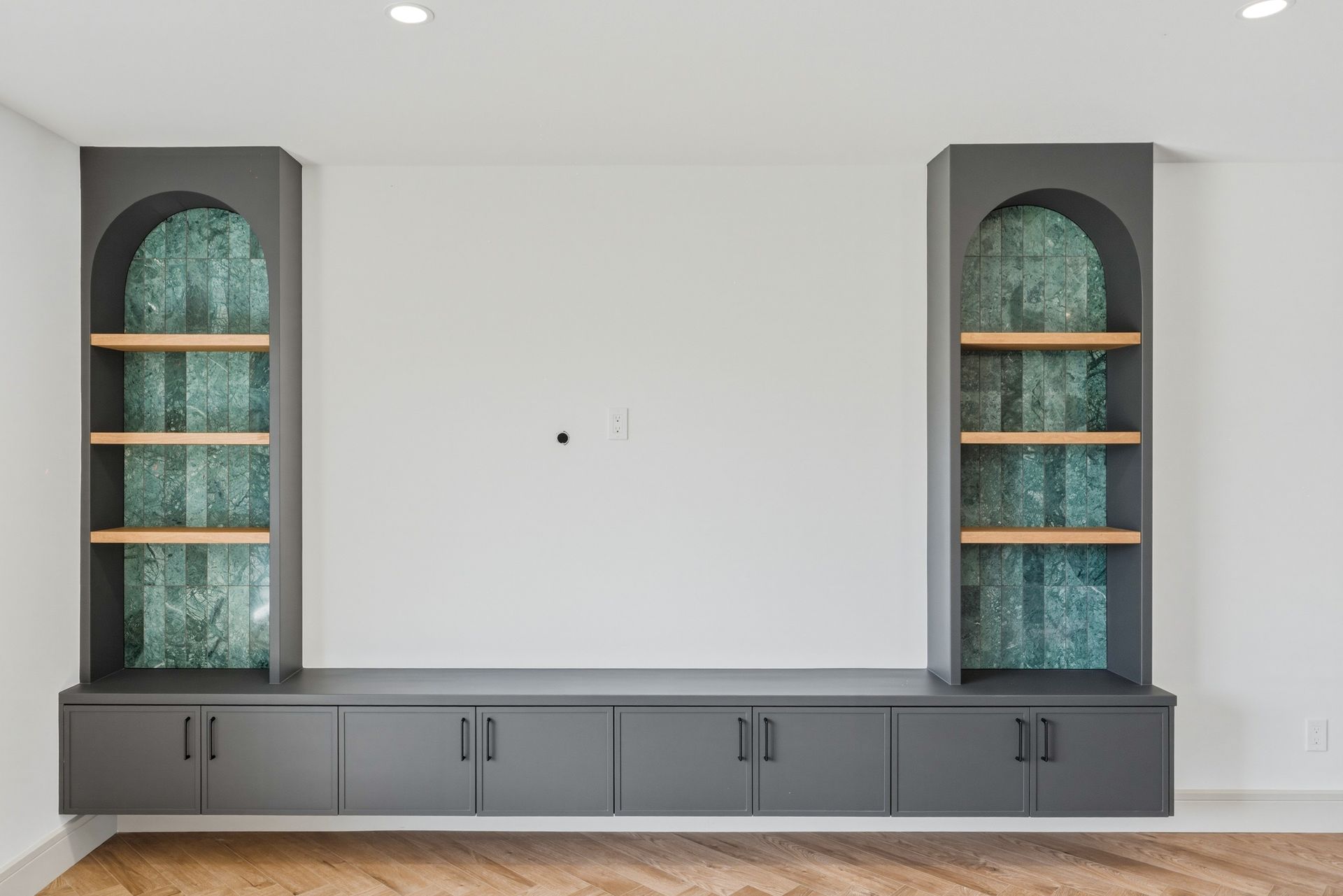 Modern wall unit with two tall gray display cabinets, lower storage drawers, and a white center wall.