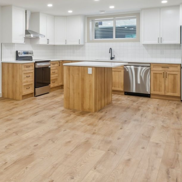 Bright modern kitchen with white cabinets, wood island, stainless appliances, and light wood flooring