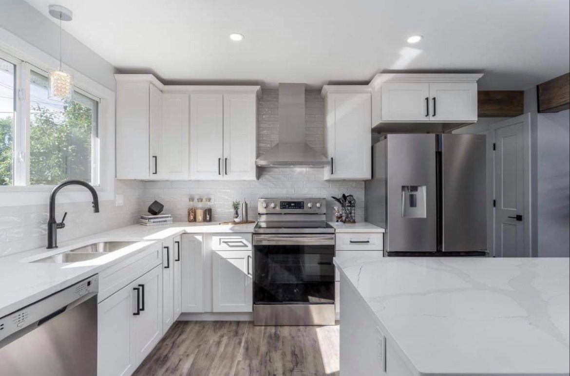 Bright modern kitchen with white cabinets, stainless steel appliances, and a gray island countertop