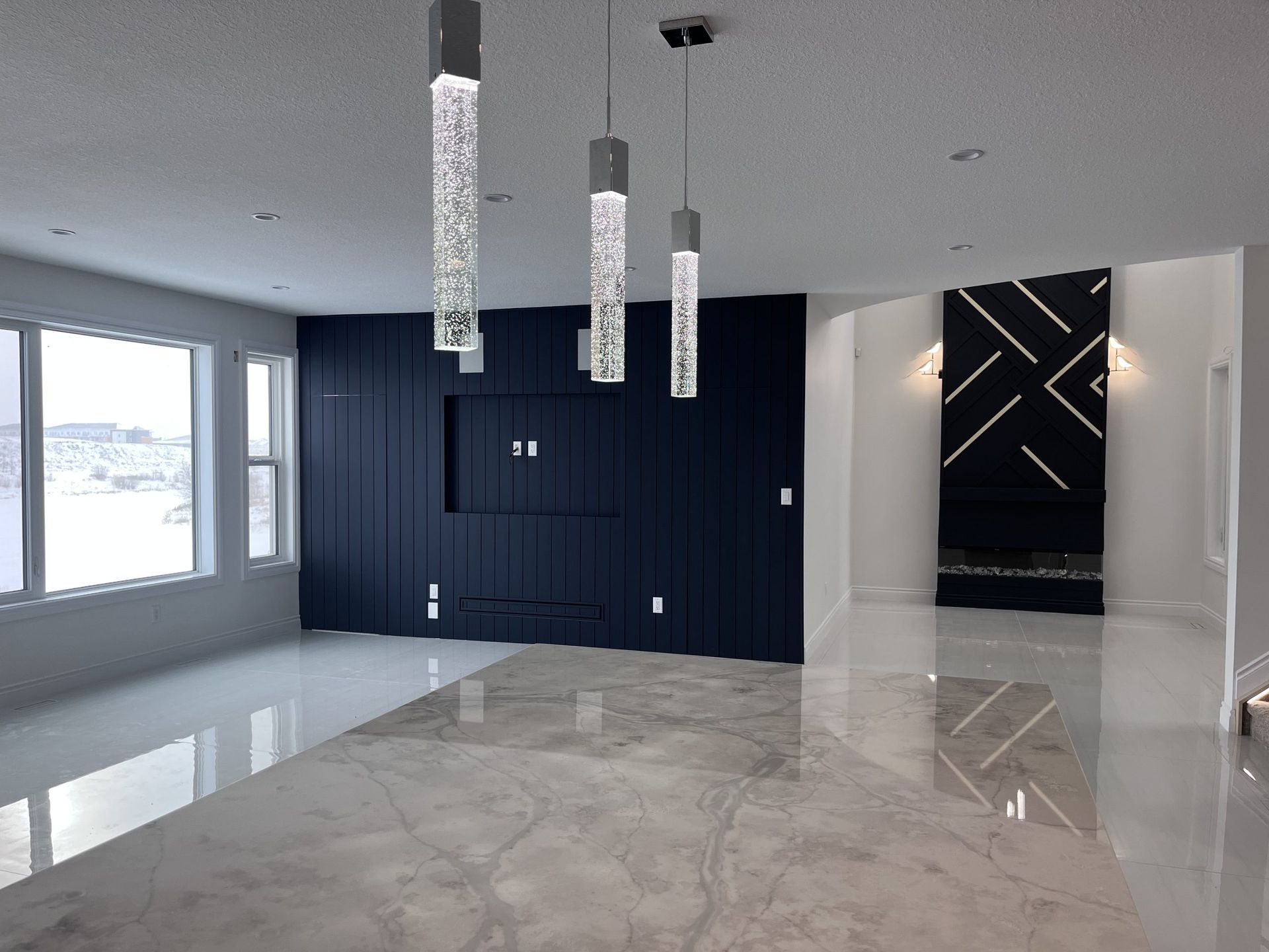 Modern open-plan living room with glossy marble floor, dark built-in cabinetry, pendant lights, and large windows.