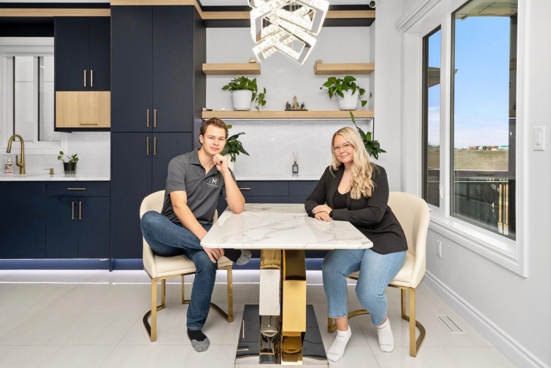 Two people sitting at a kitchen island in a bright modern kitchen