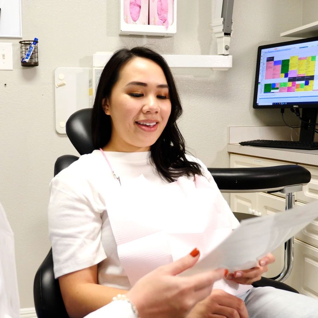 Ozone Therapy | Natural Dentist Near Marrero LA woman looking at paper in dentist office chair | Ozone Therapy | Holistic dentist Marrero LA
