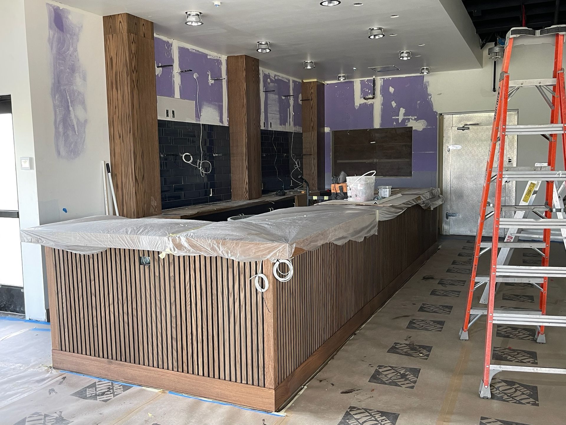 Bar under construction with wood and stone features. A ladder is present.