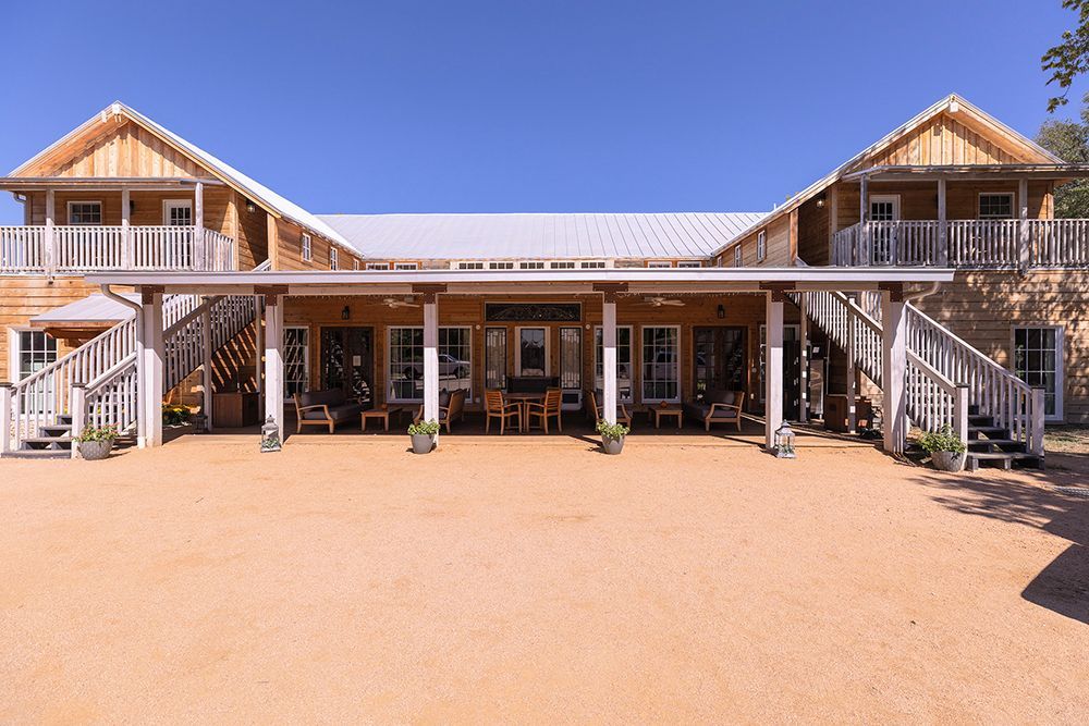 A large house with a porch and stairs in front of it.