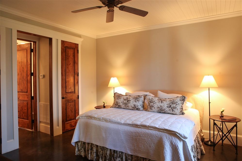A bedroom with a king size bed and a ceiling fan.