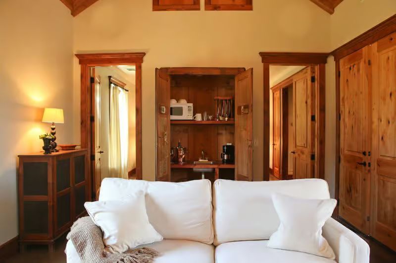 A living room with a white couch and wooden cabinets