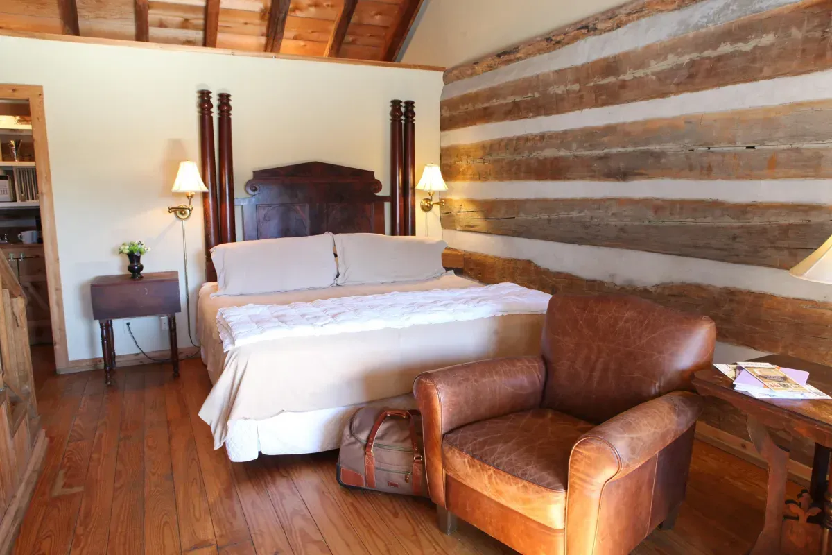 A bedroom with a king size bed and a chair