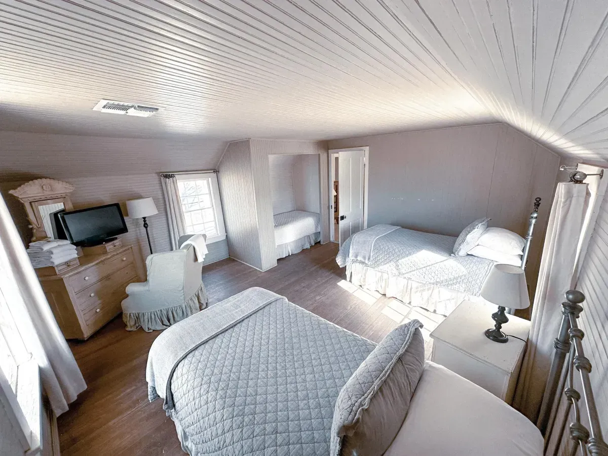 A bedroom with two beds and a television
