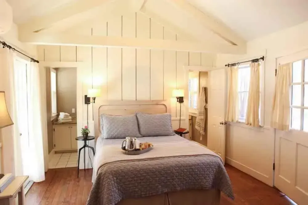 A bedroom with a bed and a tray of food on it