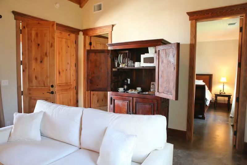 A living room with a white couch and a wooden cabinet