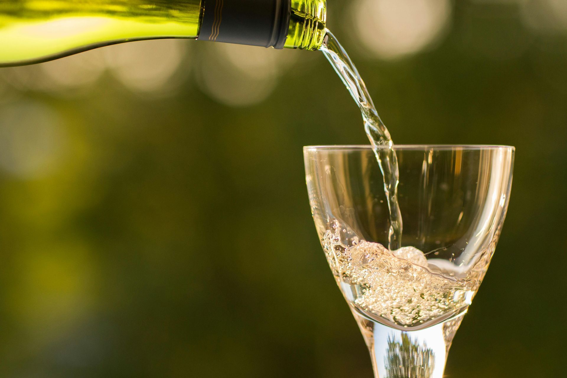 A bottle of wine is being poured into a glass.