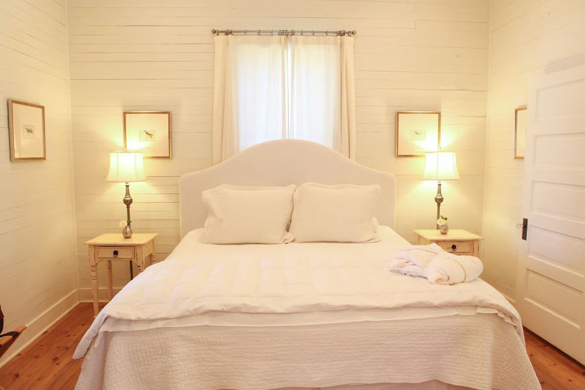 A bedroom with a bed , two nightstands and two lamps.