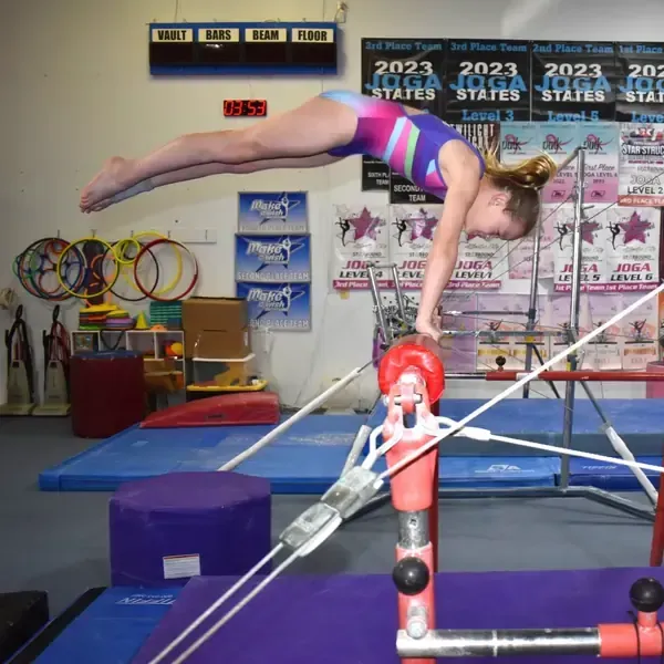 Gymnast on uneven bars at Aerials Gymnastics in Eatontown NJ