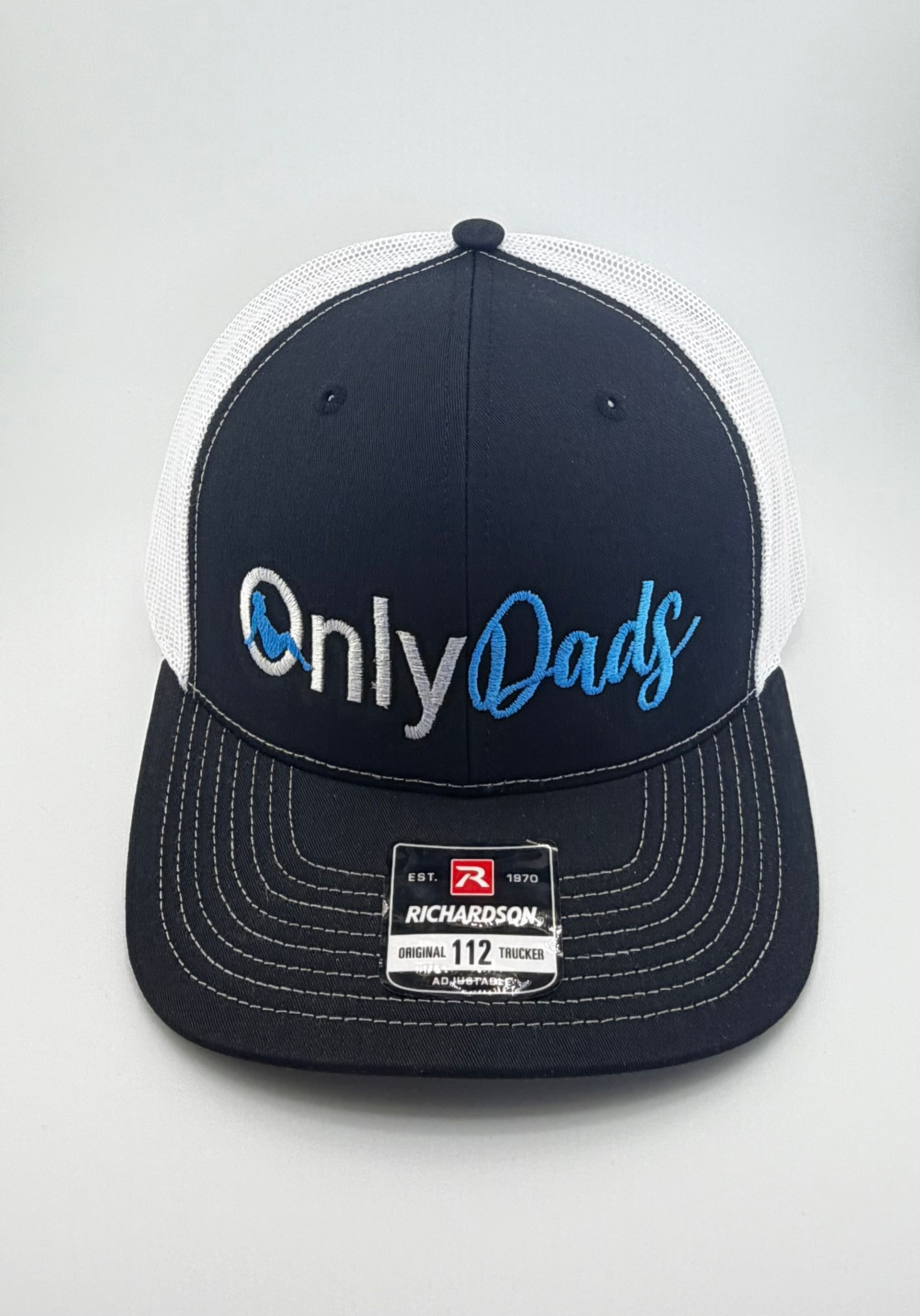 A black and white trucker hat featuring "OnlyDads" embroidered in white and blue on the front.