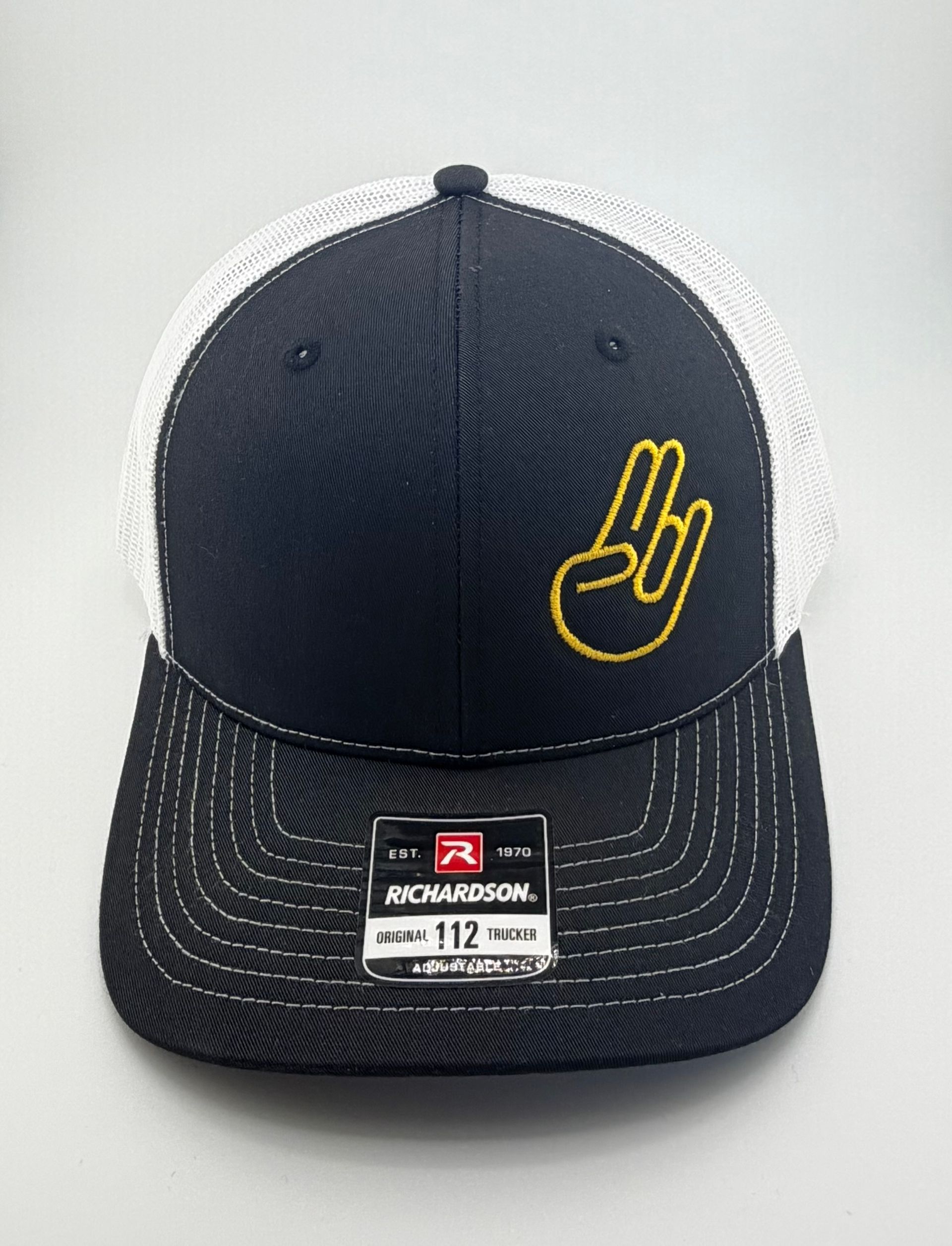 A dark blue and white trucker hat featuring an embroidered yellow hand sign logo and a Richardson brand sticker.