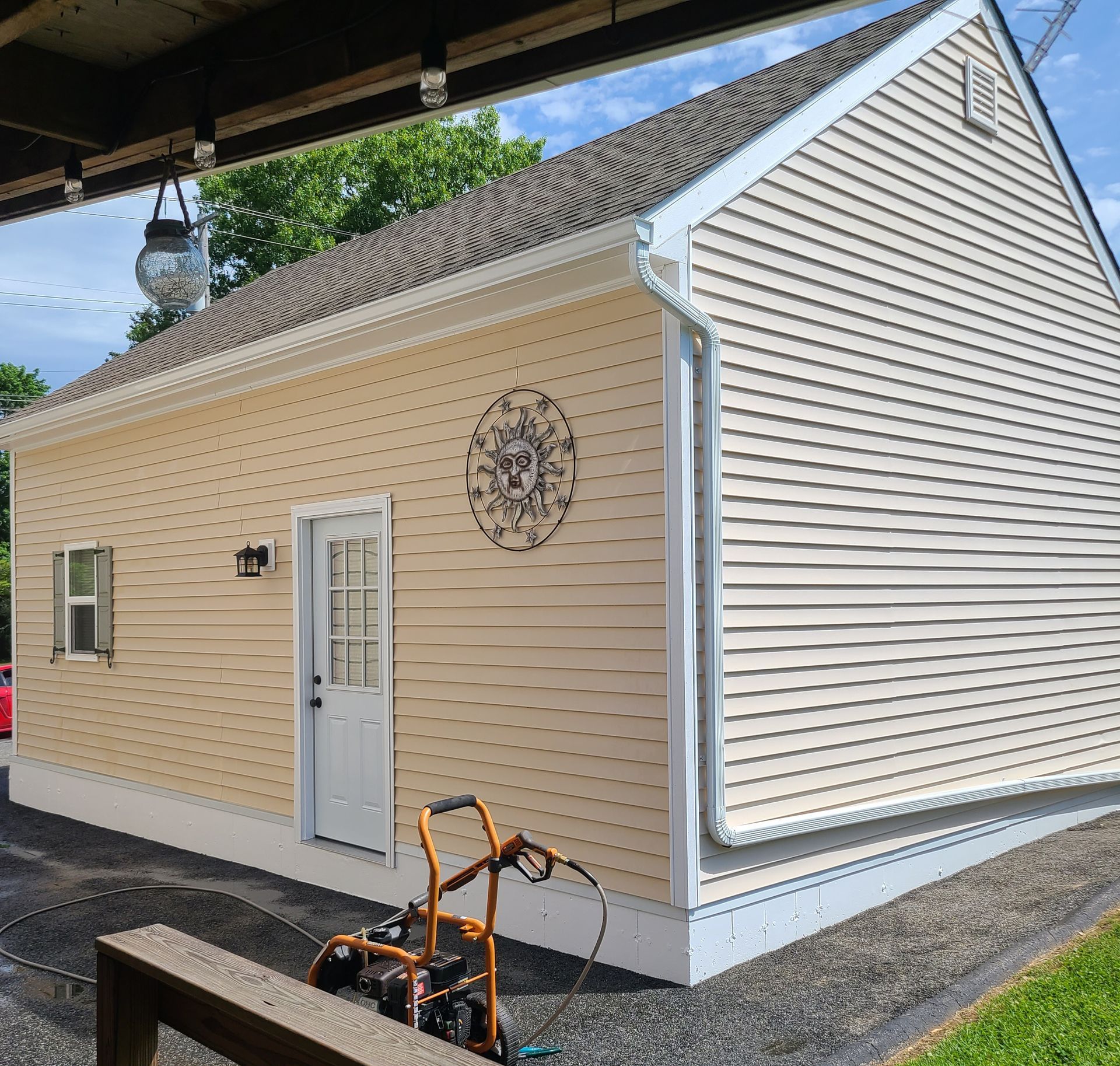 Small beige garage with white trim, side door, and decorative wall art