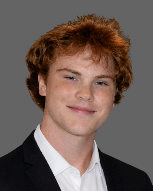 Portrait of a smiling person in a black suit jacket and white shirt on a gray background