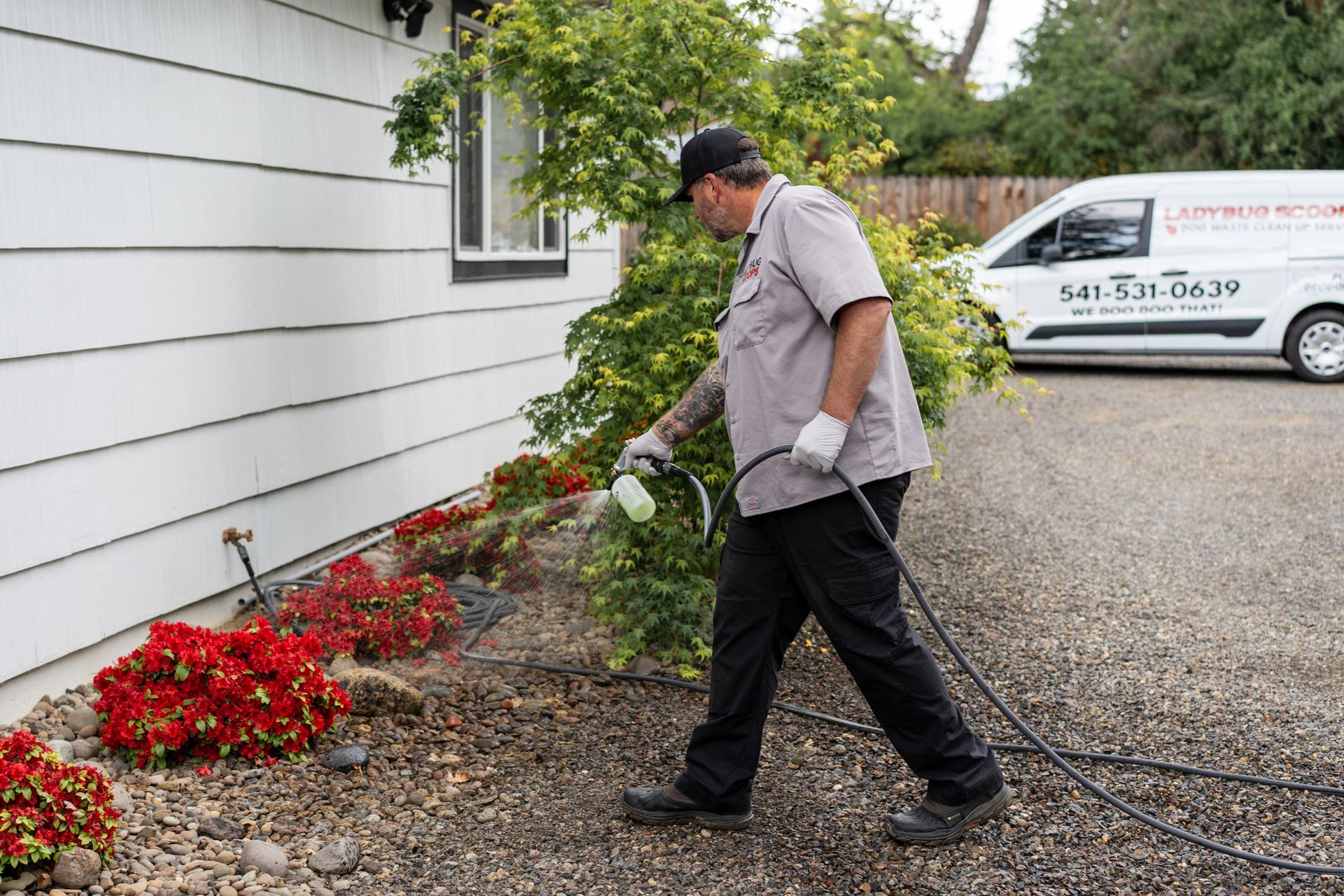 Gloved hand placing a white plastic scoop on grass outdoors