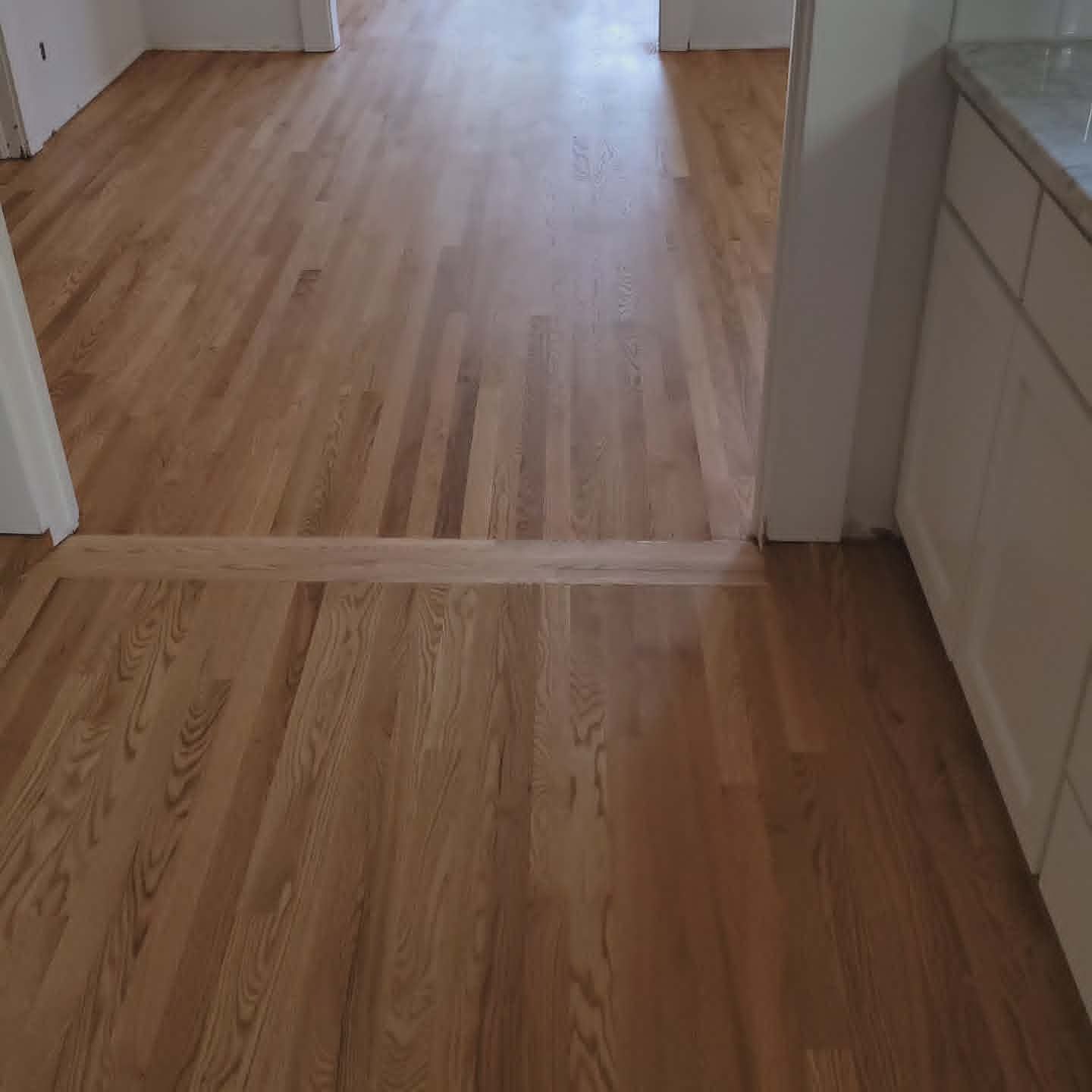 Empty room with light wood floors and a doorway leading to another room