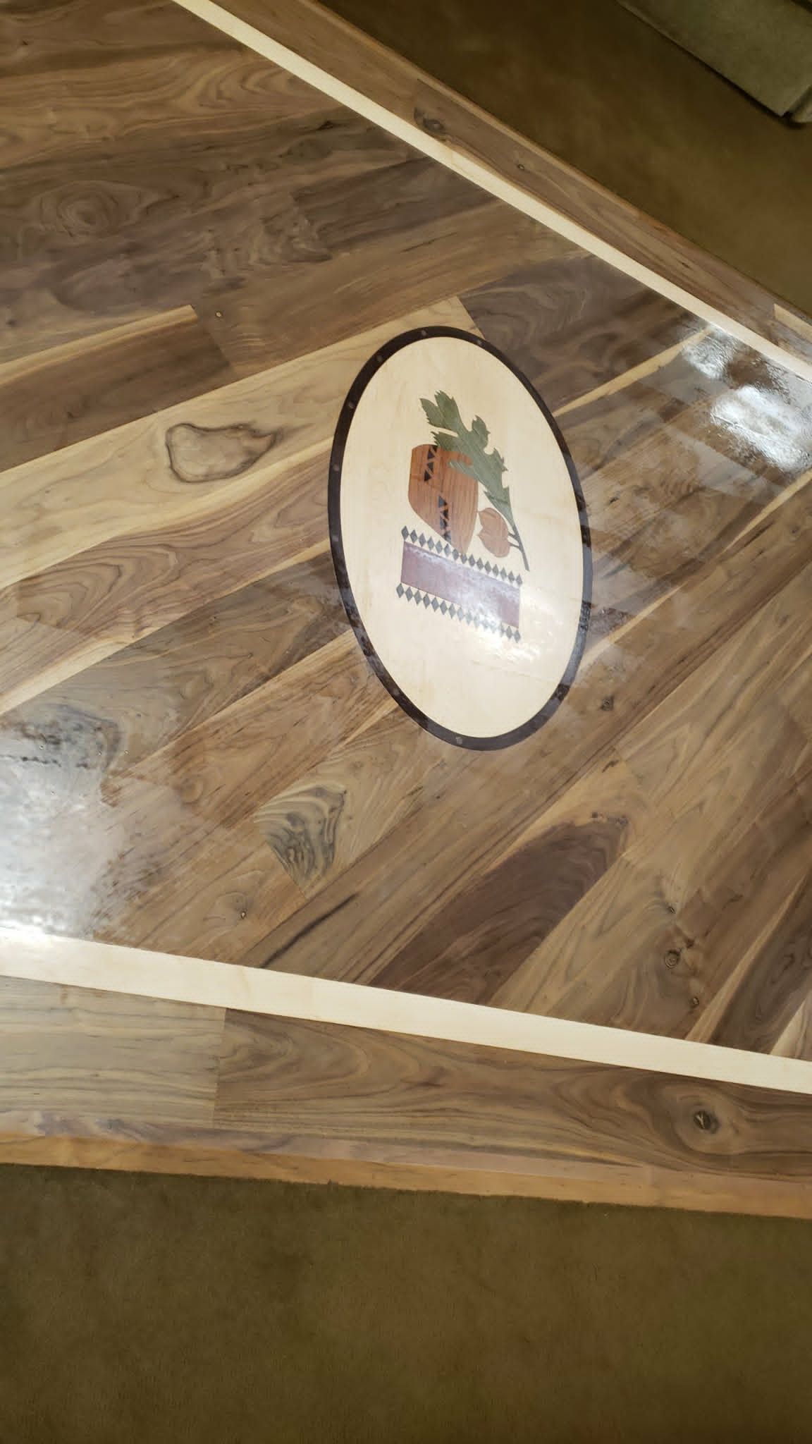 Wooden floor with a round decorative plaque in the center, bordered by cream trim.