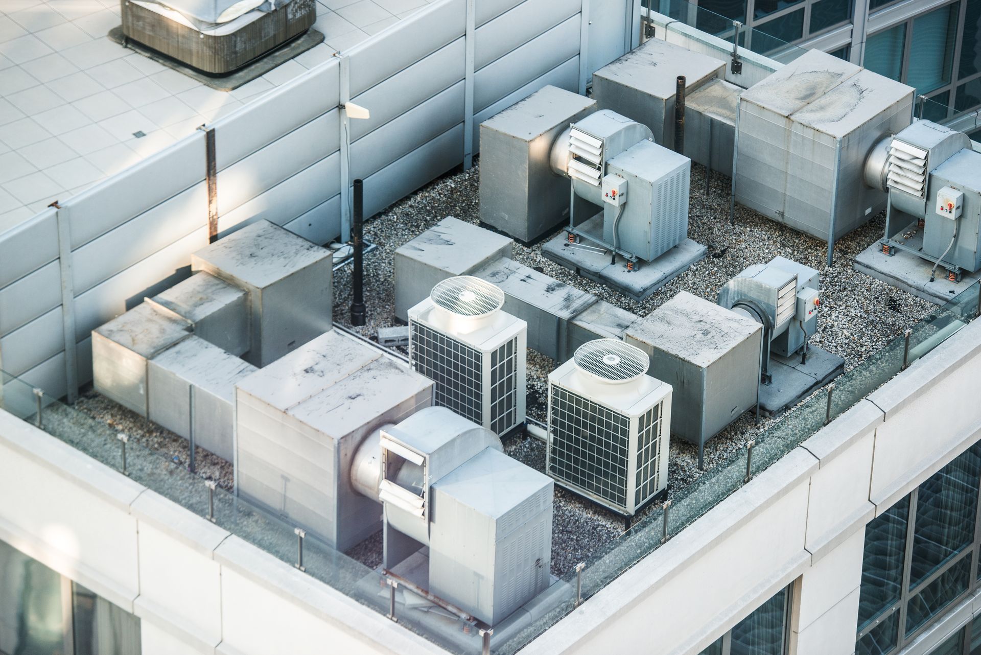 Industrial HVAC units and ventilation equipment situated on a flat building rooftop.