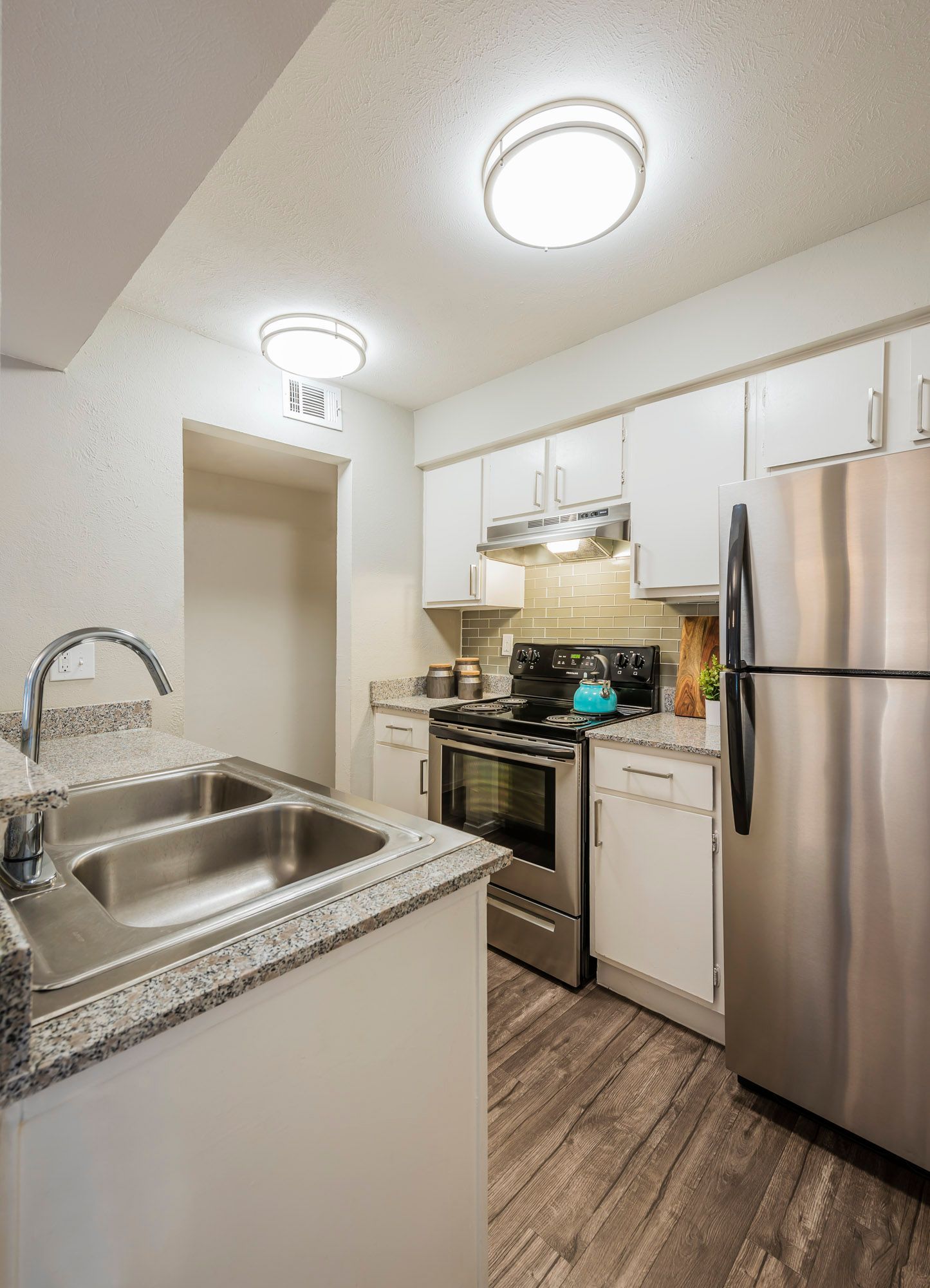 Kitchen with white cabinets, stainless steel appliances, and gray countertops.