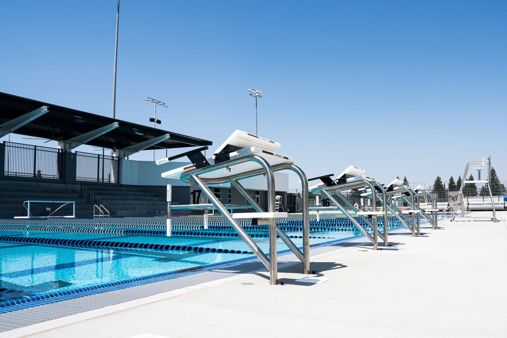 Swimming pool with diving blocks, sunny day. Empty, waiting.