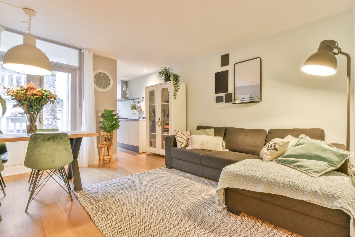 A living room with a couch , chairs and a rug.