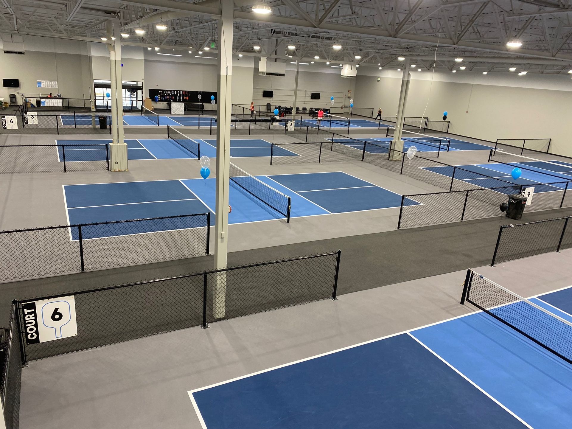 A woman is playing paddle tennis on a blue court